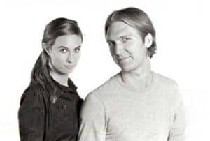 A woman and a man posing against a white background.