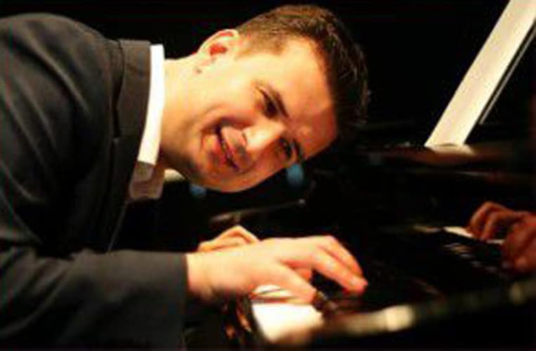 A person playing the piano with a joyful expression.
